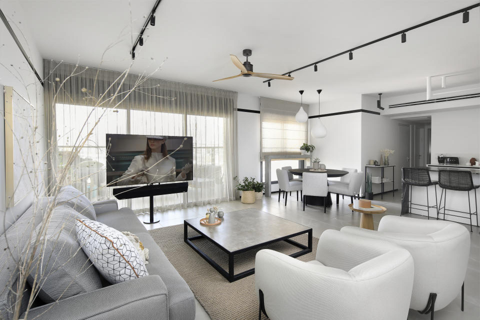 A living room with track lighting on the ceiling