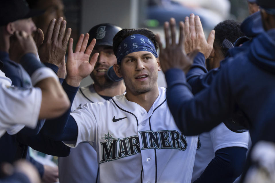 Seattle Mariners' Sam Haggerty, center, and Tom Murphy are congratulated in the dugout after scoring against the Texas Rangers during the third inning of a baseball game Tuesday, May 9, 2023, in Seattle. (AP Photo/Stephen Brashear)