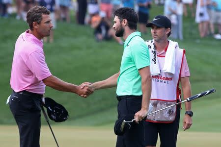 Jul 2, 2017; Potomac, MD, USA; Kyle Stanley (R) shakes hands with Charles Howell III (L) after making a par putt on the first playoff hole to win the Quicken Loans National golf tournament at TPC Potomac at Avenel Farm. Mandatory Credit: Geoff Burke-USA TODAY Sports