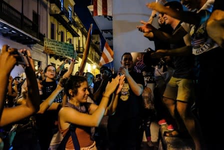 Demonstrators chant and wave Puerto Rican flags during the fourth day of protest calling for the resignation of Governor Ricardo Rossello in San Juan