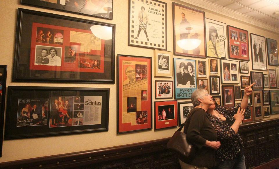 Guests walk down a Tangier hallway in 2015 and admire the photos and posters of entertainers who performed at the Akron restaurant and cabaret.