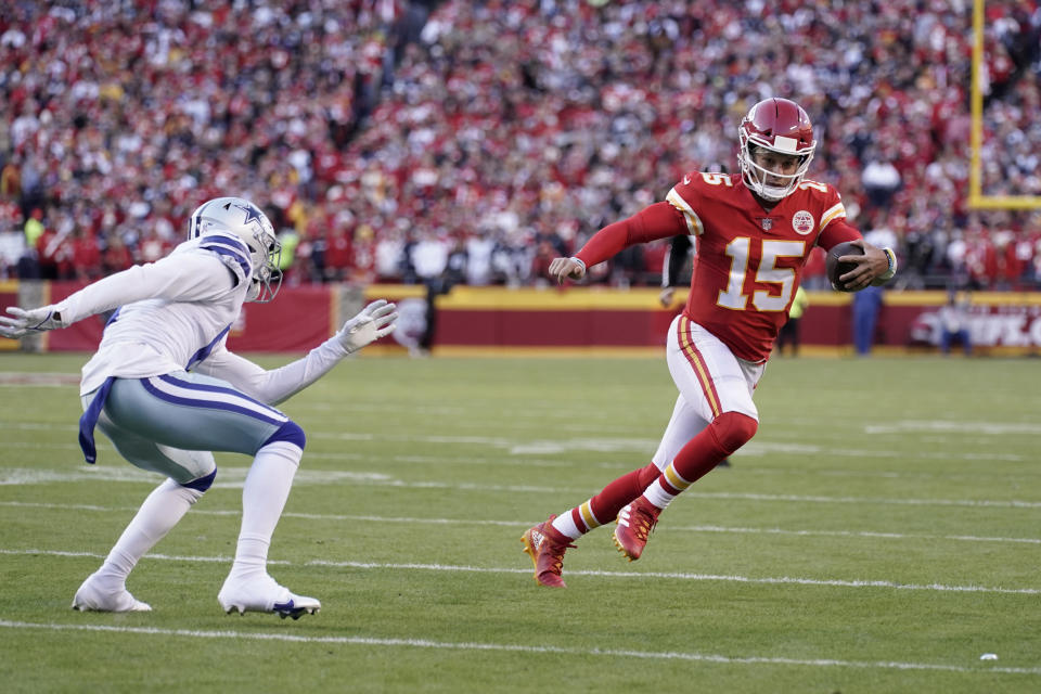 Kansas City Chiefs quarterback Patrick Mahomes, right, runs with the ball as Dallas Cowboys safety Donovan Wilson, left, defends during the first half of an NFL football game Sunday, Nov. 21, 2021, in Kansas City, Mo. (AP Photo/Charlie Riedel)