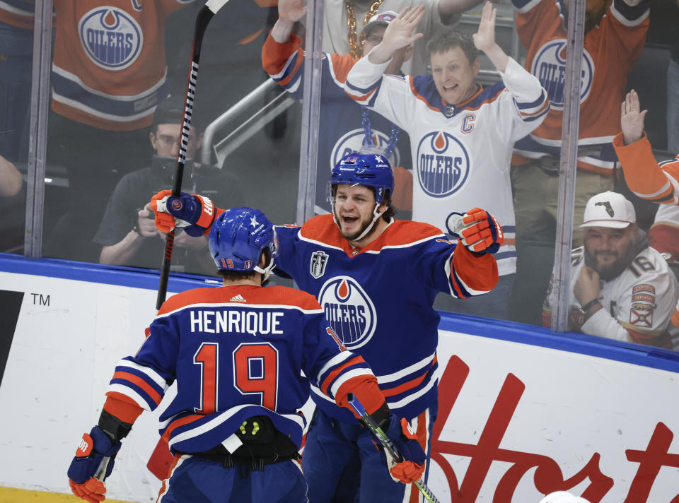 Edmonton Oilers' Mattias Janmark (13) celebrates with Adam Henrique (19) after Janmark's goal against the Florida Panthers during the first period of Game 4 of the NHL hockey Stanley Cup Final, Saturday, June 15, 2024, in Edmonton, Alberta. (Jeff McIntosh/The Canadian Press via AP)