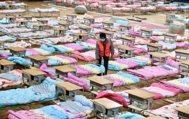 A worker sets up beds at the Hongshan Stadium to convert it into a makeshift hospital following an outbreak of the new coronavirus, in Wuhan, Hubei province, China February 4, 2020.