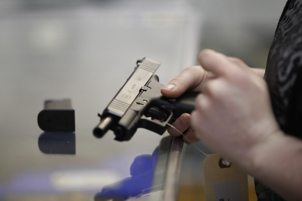A potential buyer holds a Glock in their right hand.