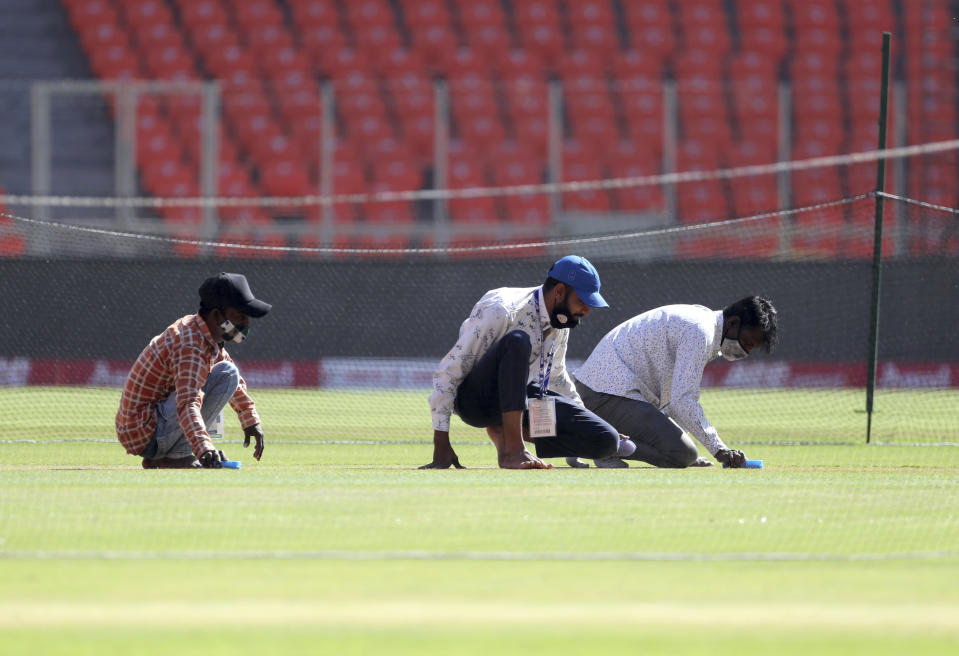 Ground staff work in the pitch area ahead of the fourth test cricket match between India and England at Narendra Modi Stadium in Ahmedabad, India, Wednesday, March 3, 2021. (AP Photo/Aijaz Rahi)