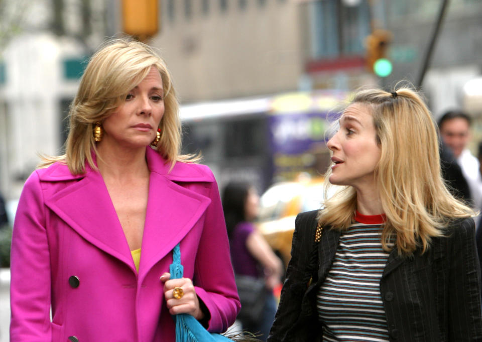 Kim Cattrall and Sarah Jessica Parker walking down a NYC street while filming Sex and the City