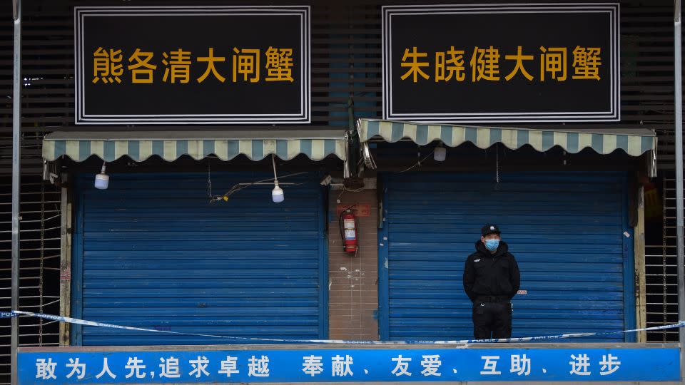 A security guard stands outside a meat market in Wuhan linked to some of the earliest known cases of Covid-19.  -Hector Retamal/AFP/Getty Images