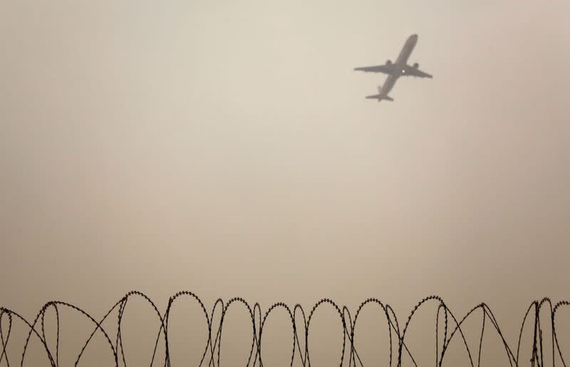 FILE PHOTO: A plane flies in the polluted air in Beijing
