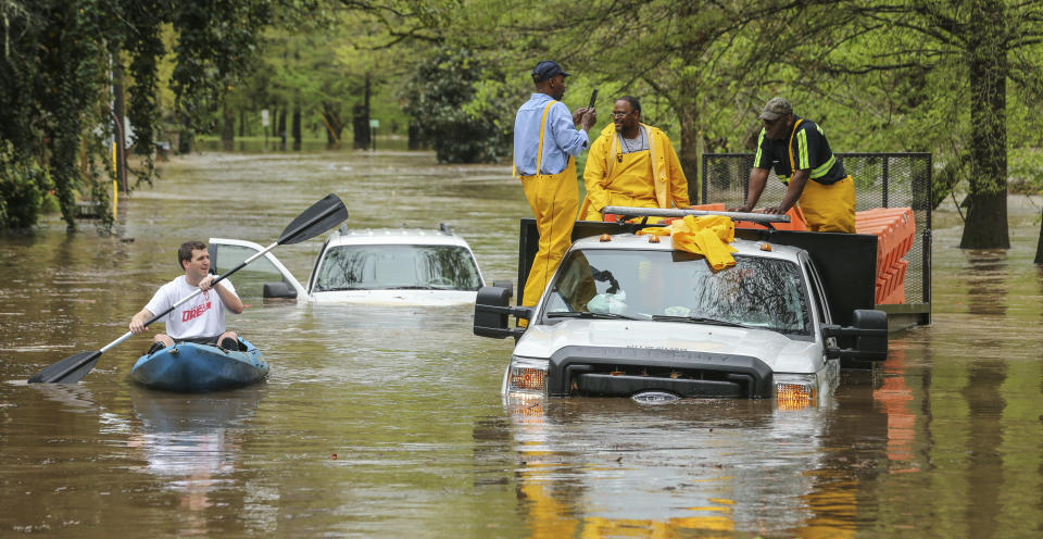 An Atlanta Public Works crew got caught in the Peachtree Creek overflow onto the flooded Woodward Way as they were delivering Road Block equipment and had to be rescued by the Atlanta Fire Rescue's Swift Water Dive Team in Atlanta, Wednesday, April 5, 2017. Severe storms raking the Southeast unleashed one large tornado and more than a half dozen apparent twisters Wednesday, toppling trees, roughing up South Carolina's "peach capital" and raining out golfers warming up for the Masters. (John Spink/Atlanta Journal-Constitution via AP)