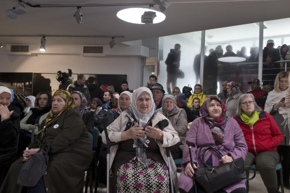 People gather at the Potocari memorial center for victims of the Srebrenica genocide, as they await the decision of the UN appeals judges on former Bosnian Serb leader Radovan Karadzic in Potocari, Bosnia and Herzegovina, Wednesday, March 20, 2019. United Nations appeals judges on Wednesday upheld the convictions of Karadzic for genocide, war crimes and crimes against humanity, and increased his sentence from 40 years to life imprisonment. (AP Photo/Marko Drobnjakovic)