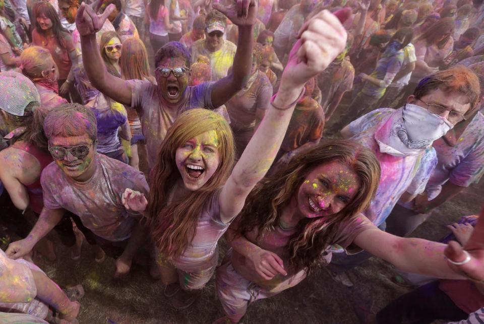 Revelers covered in colored corn starch celebrate during the 2014 Festival of Colors, Holi Celebration at the Krishna Temple Saturday, March 29, 2014, in Spanish Fork, Utah. Nearly 70,000 people are expected to gather starting Saturday at a Sri Sri Radha Krishna Temple in Spanish Fork for the annual two-day festival of colors. Revelers gyrate to music and partake in yoga during the all-day festival, throwing colored corn starch in the air once every hour. The Salt Lake Tribune reports that the large majority of participants are not Hindus, but Mormons. Thousands of students from nearby Brigham Young University come to take part in a festival that is drug and alcohol free. The event stems from a Hindu tradition celebrating the end of winter and the triumph of good over evil. (AP Photo/Rick Bowmer)