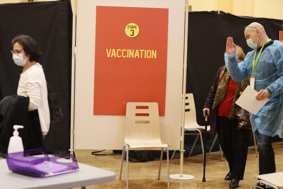 A medical worker talks to woman in a vaccination center using the Pfizer vaccine in Strasbourg, eastern France, Thursday, March 18, 2021. France is set to announce new coronavirus restrictions on Thursday, including a potential lockdown in the Paris region and in the north of the country, as the number of COVID-19 patients in intensive care units spikes. (AP Photo/Jean-Francois Badias)