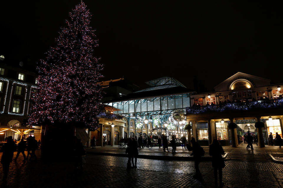 Shoppers walk near a Christmas Tree at Covent Garden in London