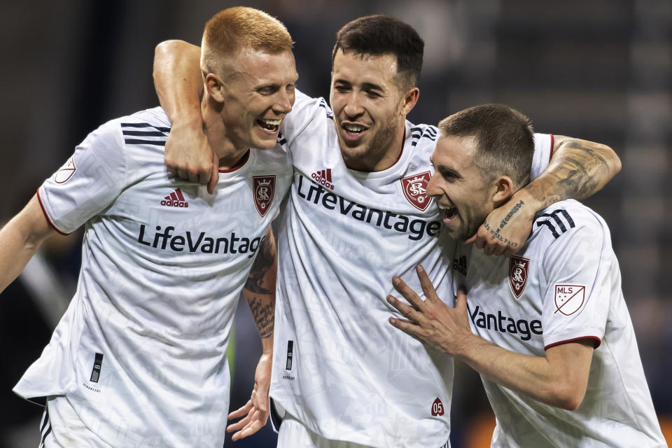 Real Salt Lake's Aaron Herrera, center, Justen Glad, left, and Andrew Brody celebrate after their team's victory over Sporting Kansas City in an MLS soccer match, Sunday, Nov. 7, 2021, in Kansas City, Kan. (AP Photo/Nick Tre. Smith)