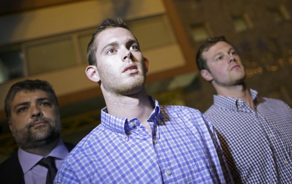 American swimmers Gunnar Bentz (center) and Jack Conger leave the police station Thursday night. (Reuters)