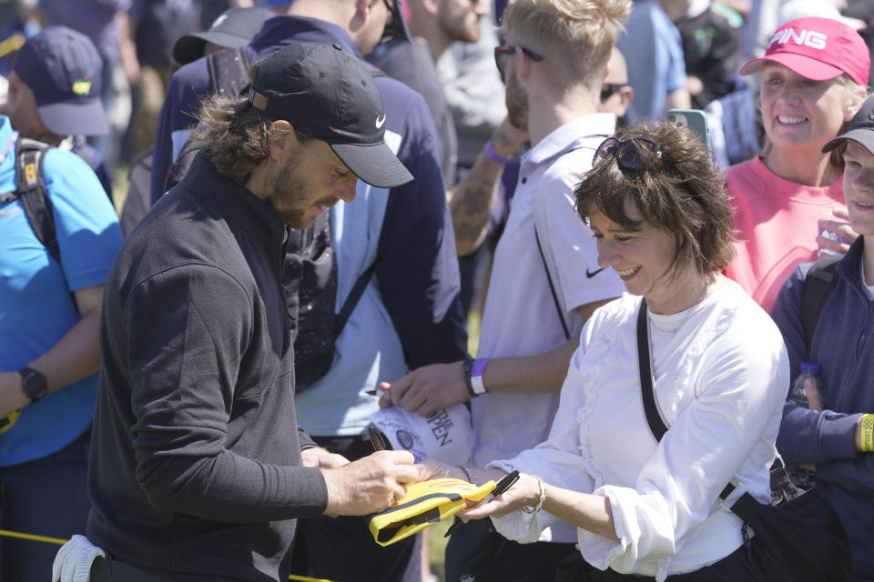 England's Tommy Fleetwood signs autographs on the 12th tee during a practice round for the British Open Golf Championships at the Royal Liverpool Golf Club in Hoylake, England, Wednesday, July 19, 2023. The Open starts Thursday, July 20. (AP Photo/Kin Cheung)