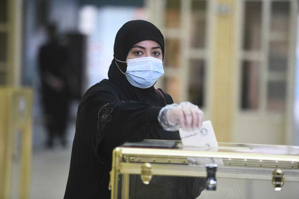 A woman casts her vote for parliamentary elections in the town of Hawally, Kuwait, Saturday, Dec. 5, 2020. (AP Photo/Jaber Abdulkhaleg)