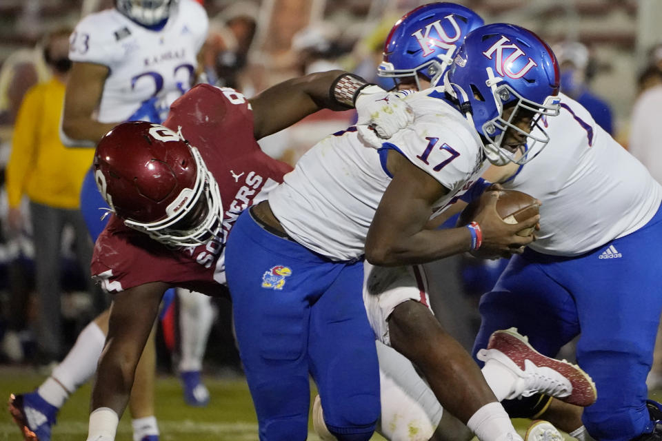 Oklahoma defensive lineman Isaiah Thomas (95) sacks Kansas quarterback Jalon Daniels (17) in the second half of an NCAA college football game in Norman, Okla., Saturday, Nov. 7, 2020. (AP Photo/Sue Ogrocki)