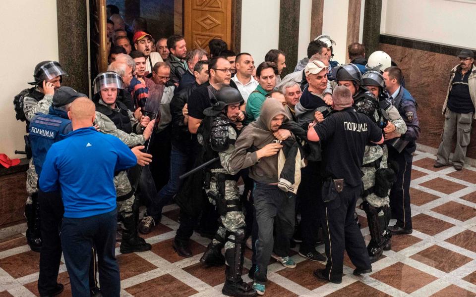 Police officers try to contain protesters as they force their way into Macedonia's parliament  - Credit: AFP