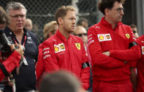 Ferrari driver Sebastian Vettel of Germany, center, and Ferrari team principal Mattia Binotto, right, stand during a moment of silence for Formula 2 driver Anthoine Hubert at the Belgian Formula One Grand Prix circuit in Spa-Francorchamps, Belgium, Sunday, Sept. 1, 2019. The 22-year-old Hubert died following an estimated 160 mph (257 kph) collision on Lap 2 at the high-speed Spa-Francorchamps track, which earlier Saturday saw qualifying for Sunday's Formula One race. (AP Photo/Francisco Seco)
