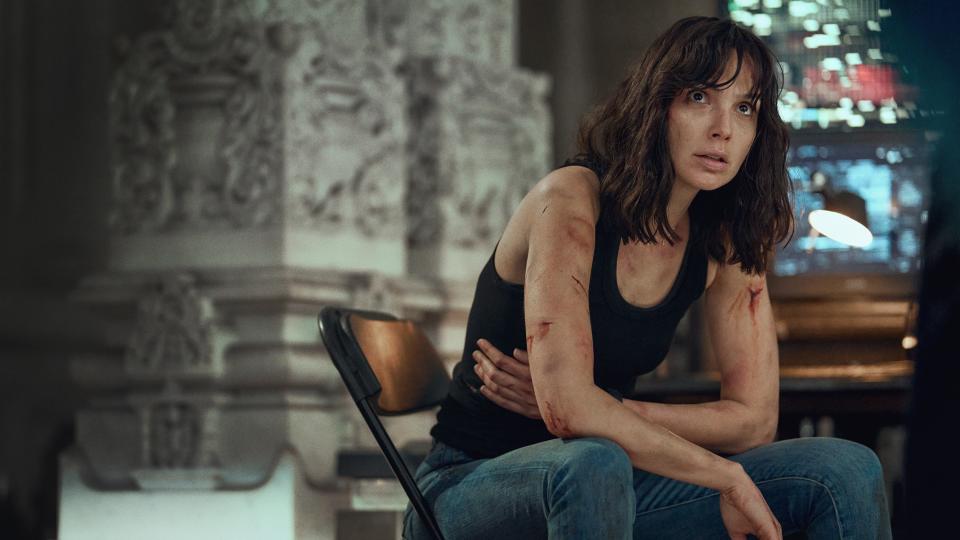 A bloodied Rachel Stone (Gal Gadot) sitting in a chair in Heart of Stone