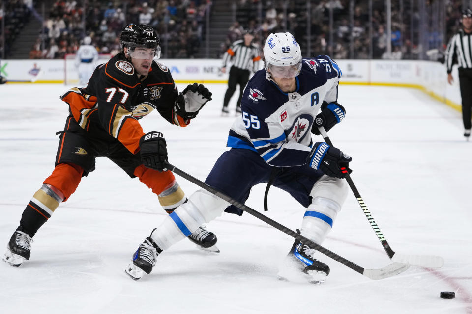 Winnipeg Jets center Mark Scheifele, right, and Anaheim Ducks right wing Frank Vatrano vie for the puck during the second period of an NHL hockey game Friday, Jan. 5, 2024, in Anaheim, Calif. (AP Photo/Ryan Sun)