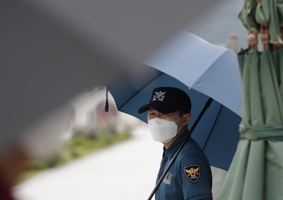 A police officer wearing face masks to help protect against the spread of the coronavirus, stand guard in downtown Seoul, South Korea, Sunday, Aug. 16, 2020. South Korea has reported 279 new coronavirus cases in the highest daily jump since early March, as fears grow about a massive outbreak in the greater capital region.(AP Photo/Lee Jin-man)