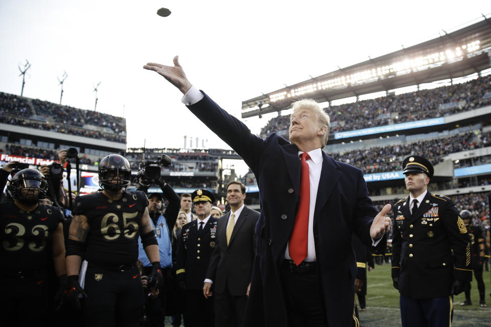 FILE - In this Dec. 8, 2018, file photo, President Donald Trump tosses the coin before the Army-Navy NCAA college football game in Philadelphia. The 120th Army-Navy game is set for Saturday in Philadelphia. President Donald Trump will attend his second straight Army-Navy game. Presidents, by custom, sit on the Army side of the stadium for one half and the Navy side for the other. (AP Photo/Matt Rourke, File)