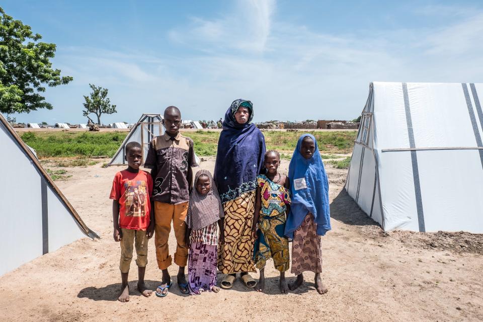 Mariam, 40, and her family stand outside their tent in Sabon Gari, Nigeria. They arrived in the village one month ago, after three years of living under a Boko Haram siege of their home village.