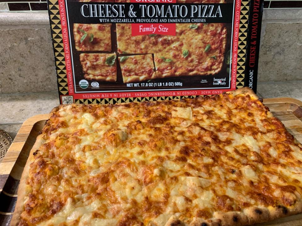 Trader Joe's cheese and tomato pizza beside black and red box