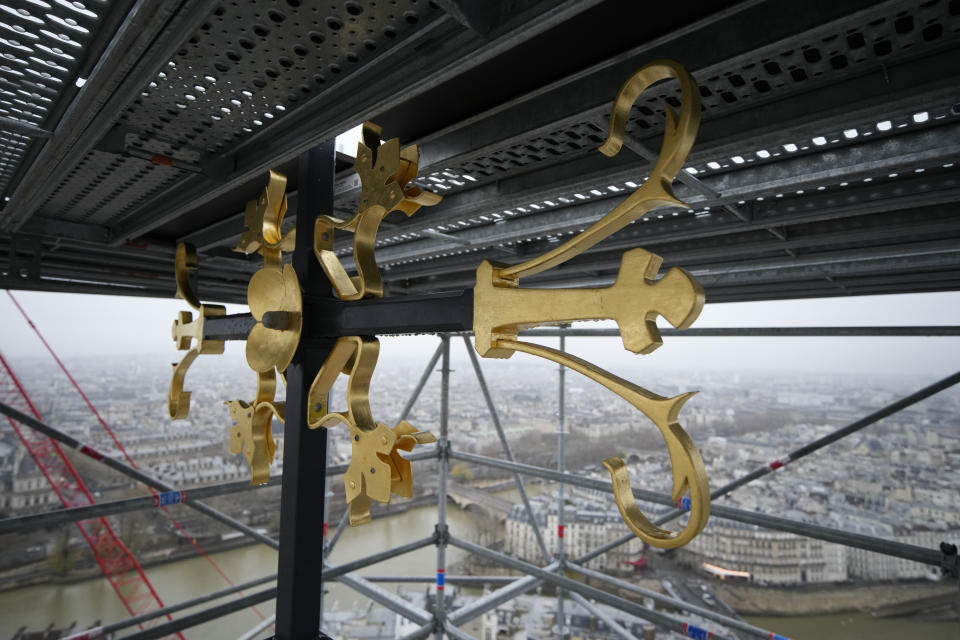 Part of the cross is seen at the top of the spire at Notre Dame de Paris cathedral Friday, Dec. 8, 2023 in Paris. French President Emmanuel Macron is visiting Notre Dame Cathedral on Friday, marking the one-year countdown to its reopening in 2024 following extensive restoration after the fire four years ago. Macron's visit, continuing his annual tradition since the blaze on April 15 2019, is aimed to highlight the progress in the works, including the near completion of the cathedral spire. (AP Photo/Christophe Ena, Pool)