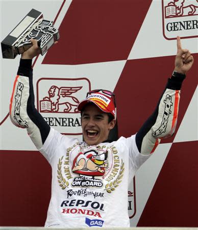 Honda MotoGP rider Spanish Marc Marquez celebrates on podium after becoming the youngest MotoGP world champion at the end of the Valencia Motorcycle Grand Prix at the Ricardo Tormo racetrack in Cheste, near Valencia, November 10, 2013. REUTERS/Heino Kalis