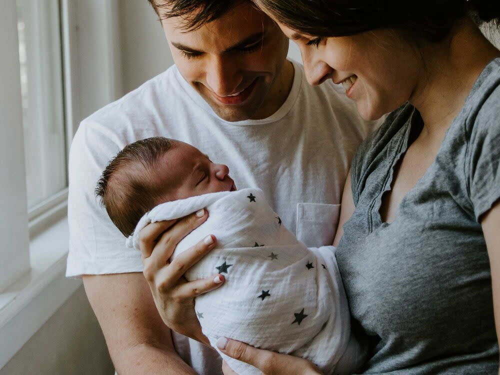 New parents holding a baby