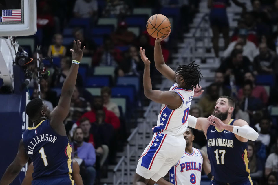 Philadelphia 76ers guard Tyrese Maxey (0) shoots between New Orleans Pelicans forward Zion Williamson (1) and center Jonas Valanciunas (17) in the first half of an NBA basketball game in New Orleans, Wednesday, Nov. 29, 2023. (AP Photo/Gerald Herbert)