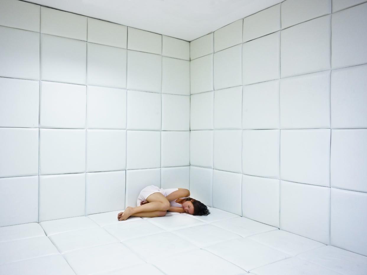 Woman in padded hospital room.
