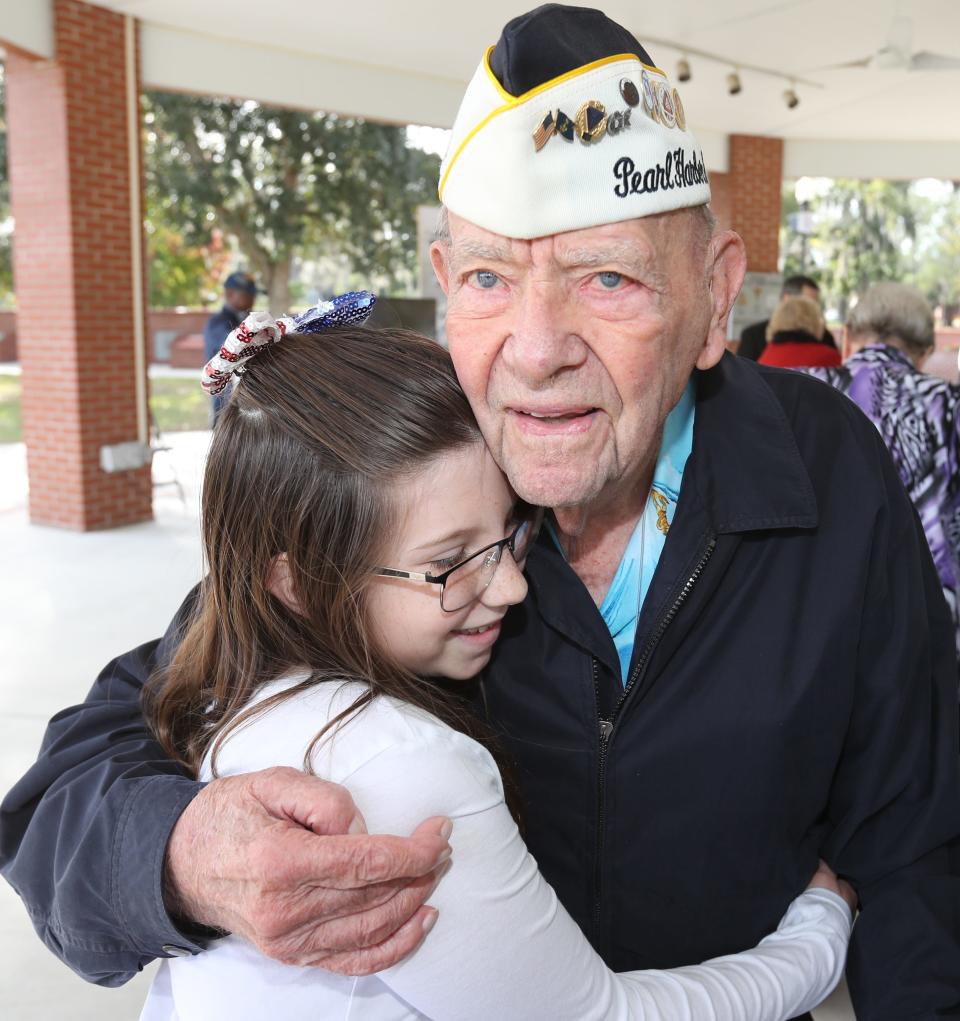 Pearl Harbor survivor Jack Edge gets a hug from his adopted granddaughter, Raegan Maze, as veterans are honored during the Pearl Harbor Remembrance Ceremony at the Ocala-Marion County Veterans Memorial Park in Ocala on Dec. 8, 2018.