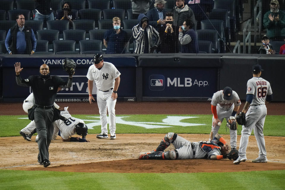 Players gather around New York Yankees' Rougned Odor (18) and Houston Astros catcher Martin Maldonado after they were injured during the sixth inning of a baseball game Tuesday, May 4, 2021, in New York. (AP Photo/Frank Franklin II)