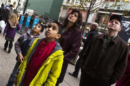 Pedestrians stop to look at holiday window displays at the Macy's flagship store in New York November 22, 2013. REUTERS/Lucas Jackson