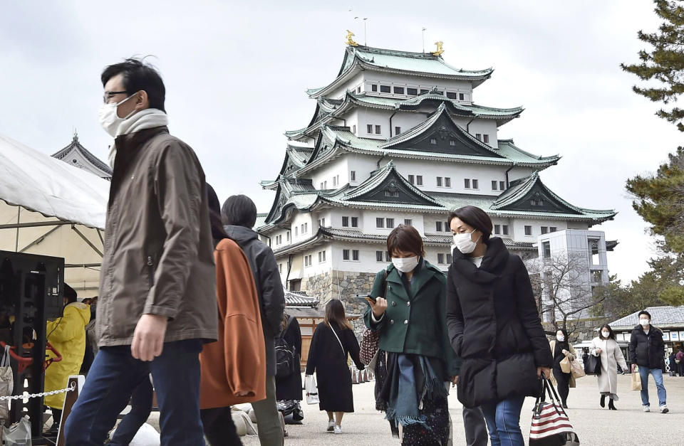 People wearing face masks visit Nagoya castle in Nagoya, central Japan, Sunday, Dec. 13, 2020. Japan’s daily coronavirus cases have exceeded 3,000 for the first time while the government delays stricter measures for fear of hurting the economy ahead of the holiday season. (Kyodo News via AP)