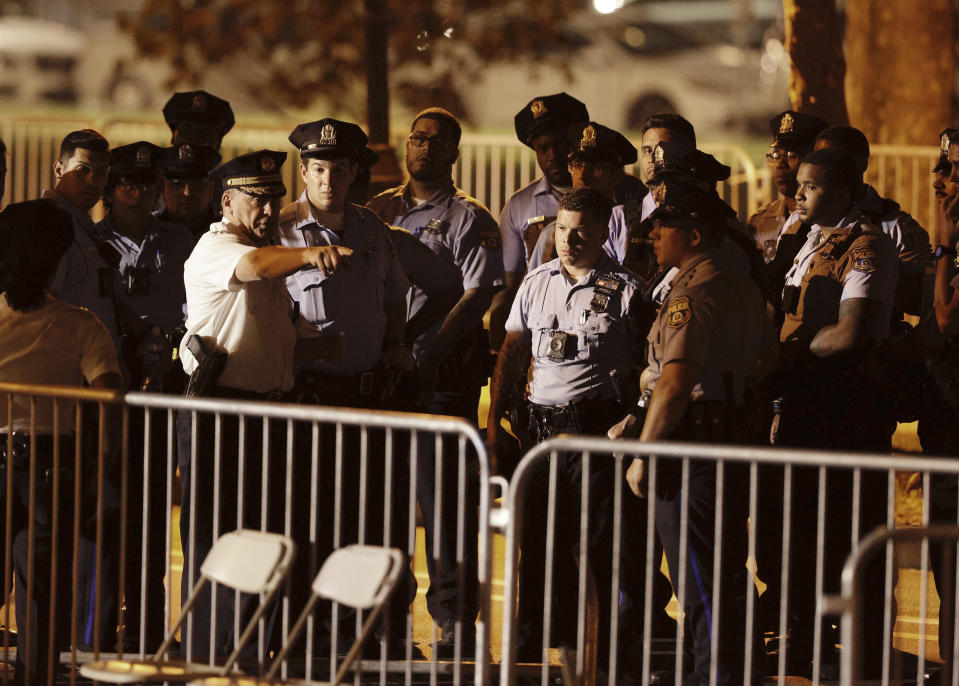 Police begin to search the seating area near the stage after two police officers were shot during the 4th of July celebration in Philadelphia on Monday, July 4, 2022. Two Philadelphia police officers working at the city’s Fourth of July celebration suffered graze wounds when shots rang out, causing scores of frightened people to flee the scene on foot. (Elizabeth Robertson/The Philadelphia Inquirer via AP)