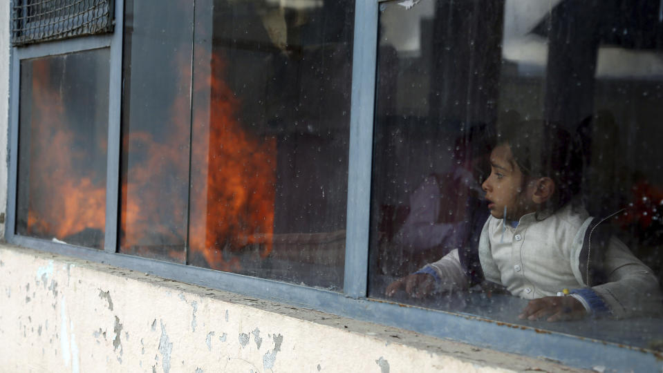 An Afghan Sikh girl looks at a funeral procession and cremation ceremony for those who were killed on Wednesday by a lone Islamic State gunman, rampaged through a Sikh house of worship, in Kabul, Afghanistan, Thursday, March 26, 2020. An explosive device disrupted Thursday's funeral service for 25 members of Afghanistan's Sikh minority community, killed in an attack by the Islamic State group on their house of worship in the heart of the capital. (AP Photo/Tamana Sarwary)