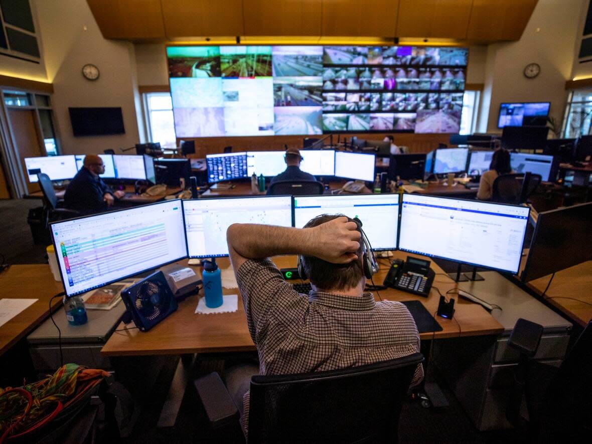 An agent at the Transportation Management Centre of British Columbia in Coquitlam monitors for road incidents on the province's vast highway network on Dec. 14, 2021.   (Ben Nelms/CBC - image credit)