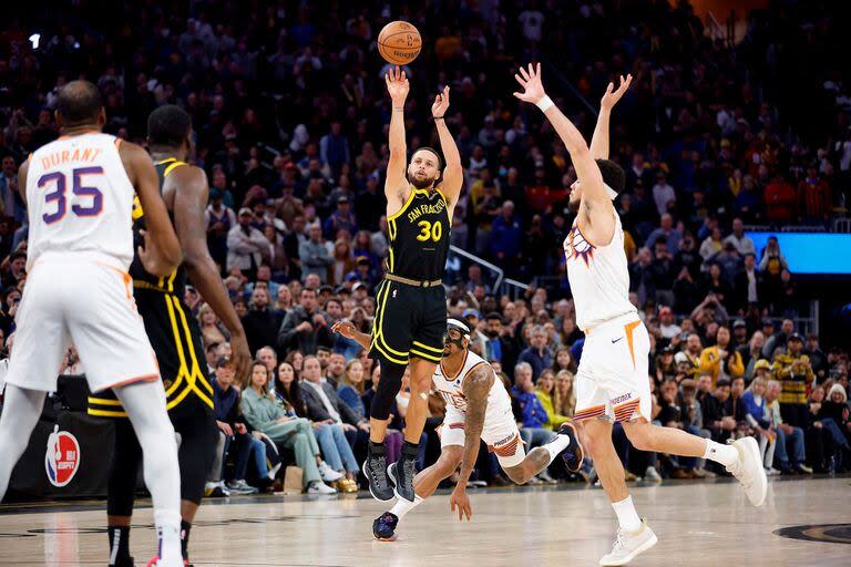 Stephen Curry en acción: Devin Booker no llega y el base de los Warriors hace su trabajo. Lachlan Cunningham/Getty Images/AFP (Photo by Lachlan Cunningham / GETTY IMAGES NORTH AMERICA / Getty Images via AFP)