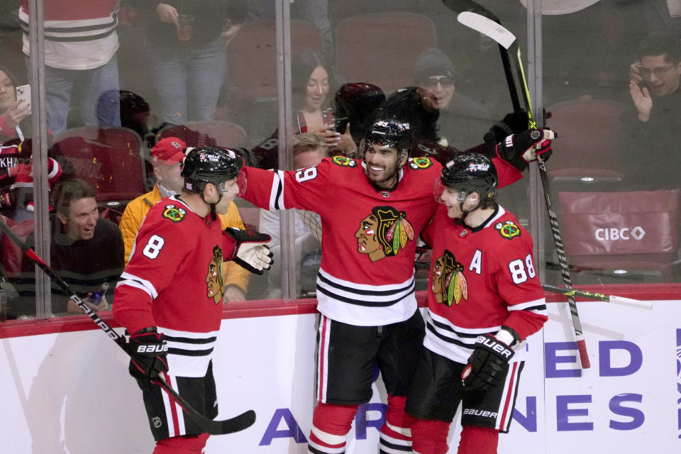 Chicago Blackhawks' Andreas Athanasiou, center, celebrates his goal with Jack Johnson (8) and Patrick Kane during the second period of an NHL hockey game against the St. Louis Blues Wednesday, Nov. 16, 2022, in Chicago. (AP Photo/Charles Rex Arbogast)