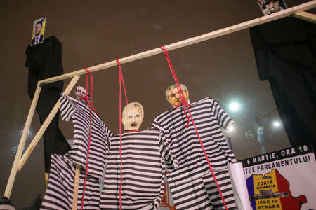 Cardboard cutouts of the Romanian Justice Minister, Tudorel Toader, Social Democrat Party leader Liviu Dragnea and Senate president, Calin Popescu Tariceanu dressed in prison garb are seen while people protest a government move to call for the sacking of the country's chief anti-corruption prosecutor in Bucharest, Romania, February 25, 2018. Inquam Photos/Octav Ganea via REUTERS