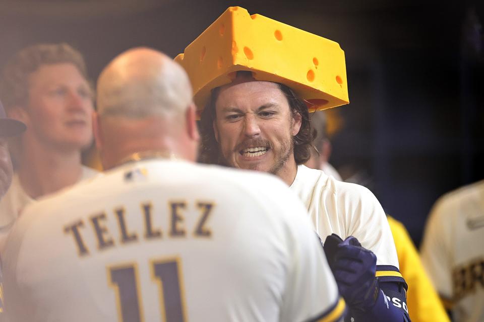 Brian Anderson of the Milwaukee Brewers celebrates a home run with a cheesehead during the sixth inning against the New York Mets of the Milwaukee Brewers at American Family Field on April 4, 2023.