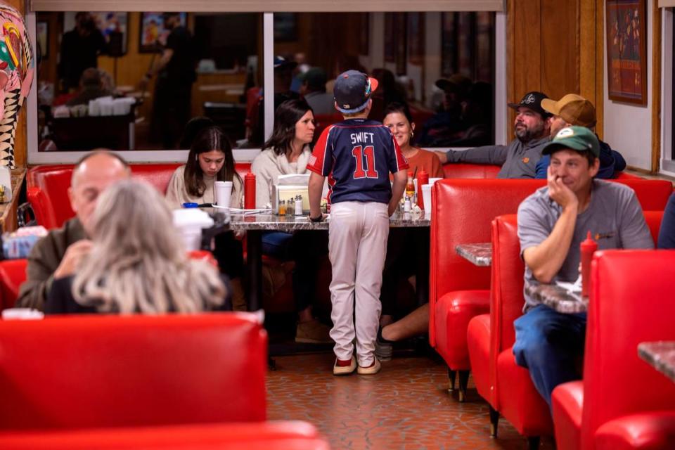 Nine-year-old Henderson Swift talks with his family after dinning with his teammates at Bar-B-Q Center on Monday, October 9, 2023 in Lexington, N.C.