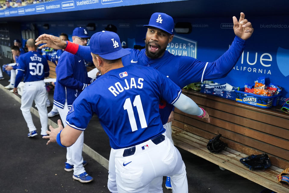 Los Angeles Dodgers shortstop Miguel Rojas (11) greets right fielder Jason Heyward before a spring training baseball game against the Los Angeles Angels in Los Angeles, Sunday, March 24, 2024. (AP Photo/Ashley Landis)