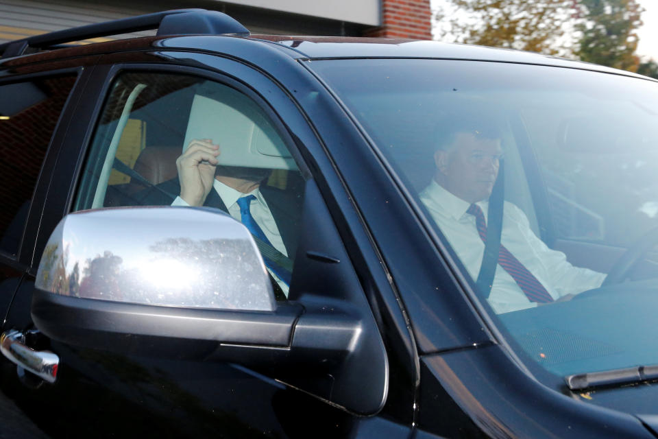 Former Trump campaign manager Paul Manafort hides behind his car visor as he leaves his home in Alexandria, Virginia. (Reuters/Jonathan Ernst)